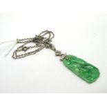 A Jade and Diamond Pendant, the carved and pierced panel below single cut diamond set surmount,