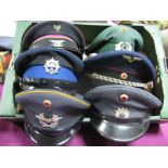 Six Second Half XX Century World Military and Civilian Peaked Caps, predominantly with badges,