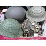 Four Post War British Military Helmets, netting camouflage noted.