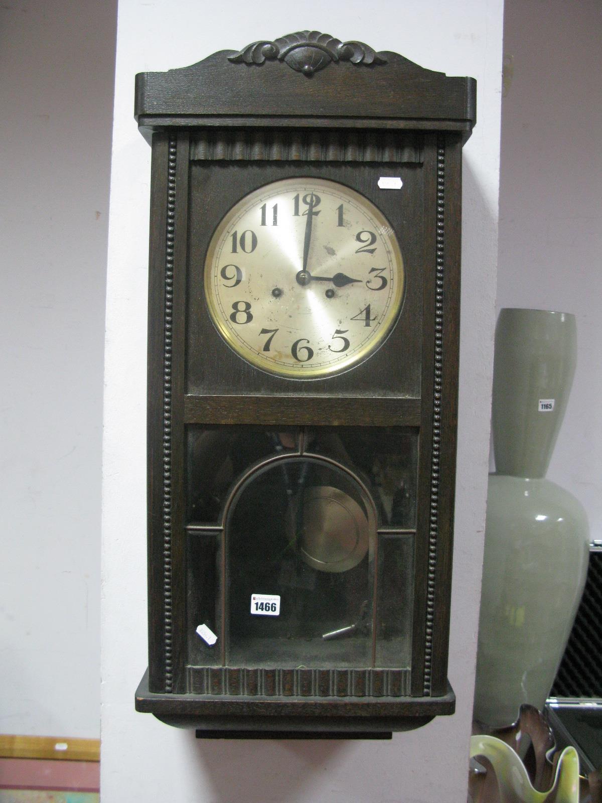 An Early XX Century Oak Cased Wall Clock, silvered dial, Arabic numerals.