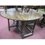 An XVIII Century Style Oak Drop Leaf Table, with carved frieze on turned and bobbin supports, united