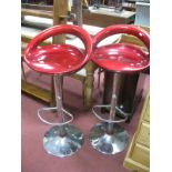 A Pair of Rise and Fall Bar Stools, metallic red seats, chrome bases. (2)