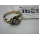 A Modern Three Stone Diamond Ring, of crossover design illusion set, stamped "375" "0.10".