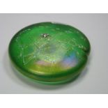 John Ditchfield Glasform; A green iridescent circular Lily Pad paperweight, mounted with a