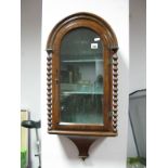 A XIX Century Walnut Wall Mounted Display Cabinet, with an arched top, glazed door barley twist