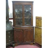 A Mahogany Double Corner Cupboard, with dentil cornice, glazed astragal doors, over cupboard