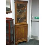 A Mahogany Double Corner Cupboard, with glazed astragal door, over a cupboard door on bracket feet.