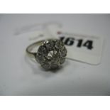 A Diamond Set Cluster Ring, the round brilliant cut centre stone claw set, within collet set border,