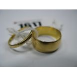 A 22ct Wide Plain Wedding Band, together with another 22ct plain wedding band. (2)