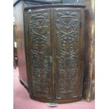 An XX Century and Later Carved Oak Bow Fronted Corner Cupboard, with carved doors, reeded sides.