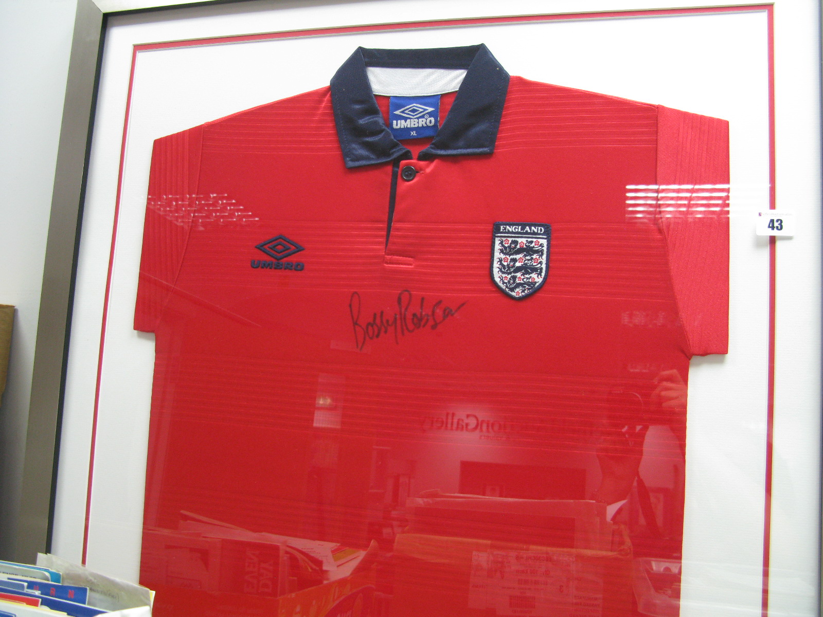 Bobby Robson, black pen autograph (unverified) on a Umbro England red away shirt, mounted glazed and