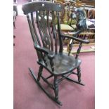 A XIX Century Style Rocking Chair, with a pierced splat, shaped arms, turned legs on rockers.