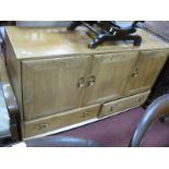 Ercol Light Ash Sideboard, having three cupboard doors, over twin drawers, on castors, 130cm wide.