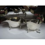 A Pair of Hallmarked Silver Sauce Boats, each with leaf capped flying scroll handle, raised on three