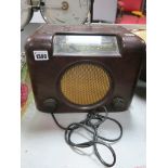 A 1950's Bush 90A Valve Radio, mottled brown Bakelite circular metal grille with lead - untested