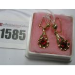 A Pair of Decorative Drop Earrings, claw set highlight, within flower head border, stamped "750".