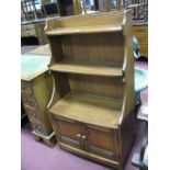 A Waterfall Bookcase in the Ercol Manner, having twin cupboard doors to base, 61cm wide.
