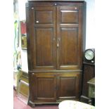 A George III Large Freestanding Oak Corner Cupboard, plain cornice over four folded panel twin