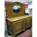 An Oak Mirror Back Sideboard, oval mirror below moulded arch, fitted with two frieze drawers over