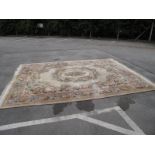 Chinese Wool Tassled Carpet, with all-over floral decoration, oval centre panel on beige ground, 306