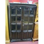 An Oak Display Cabinet, with knulled decoration, glazed doors with linen fold decoration.