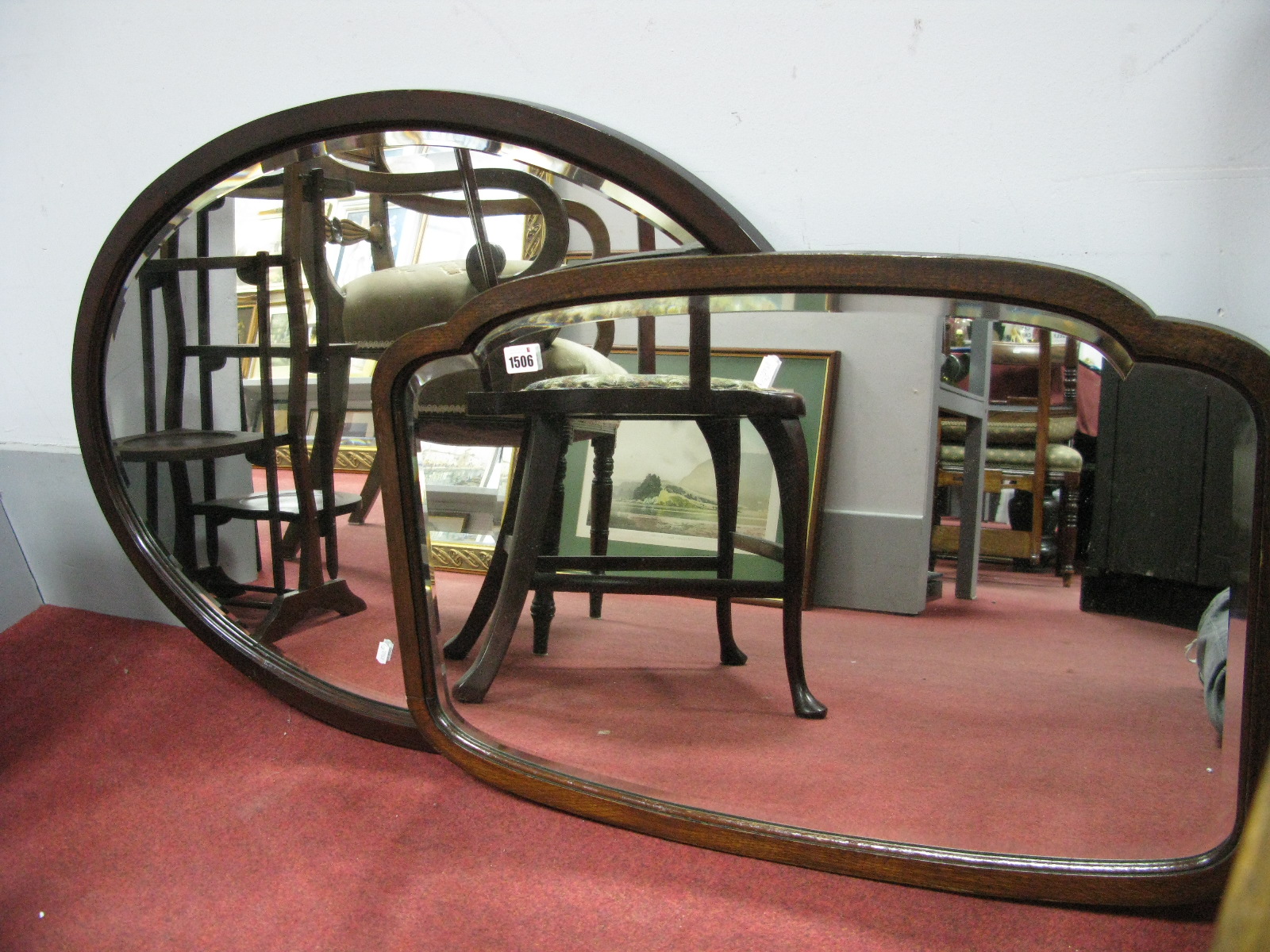 An Early XX Century Oval Bevelled Wall Mirror, in mahogany frame, another in shaped frame. (2)