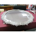 A Silver Plated Mirror Plateau, of circular form, the intricate border detailed in relief with