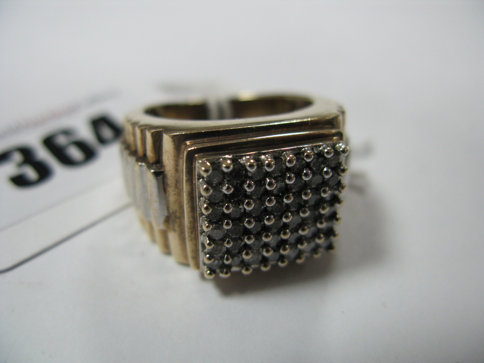 A Large Gent's Dress Ring, square claw set to the centre, between textured watch bracelet style