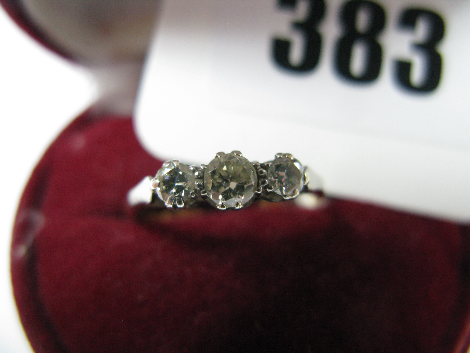 A Three Stone Diamond Ring, the graduated brilliant cut stones claw set, between tapered