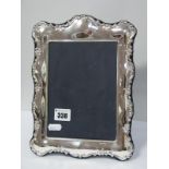 A Modern Hallmarked Silver Mounted Rectangular Photograph Frame, of shaped design, on plush blue