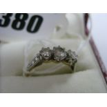 An 18ct Gold Three Stone Diamond Ring, graduated claw set between textured shoulders.