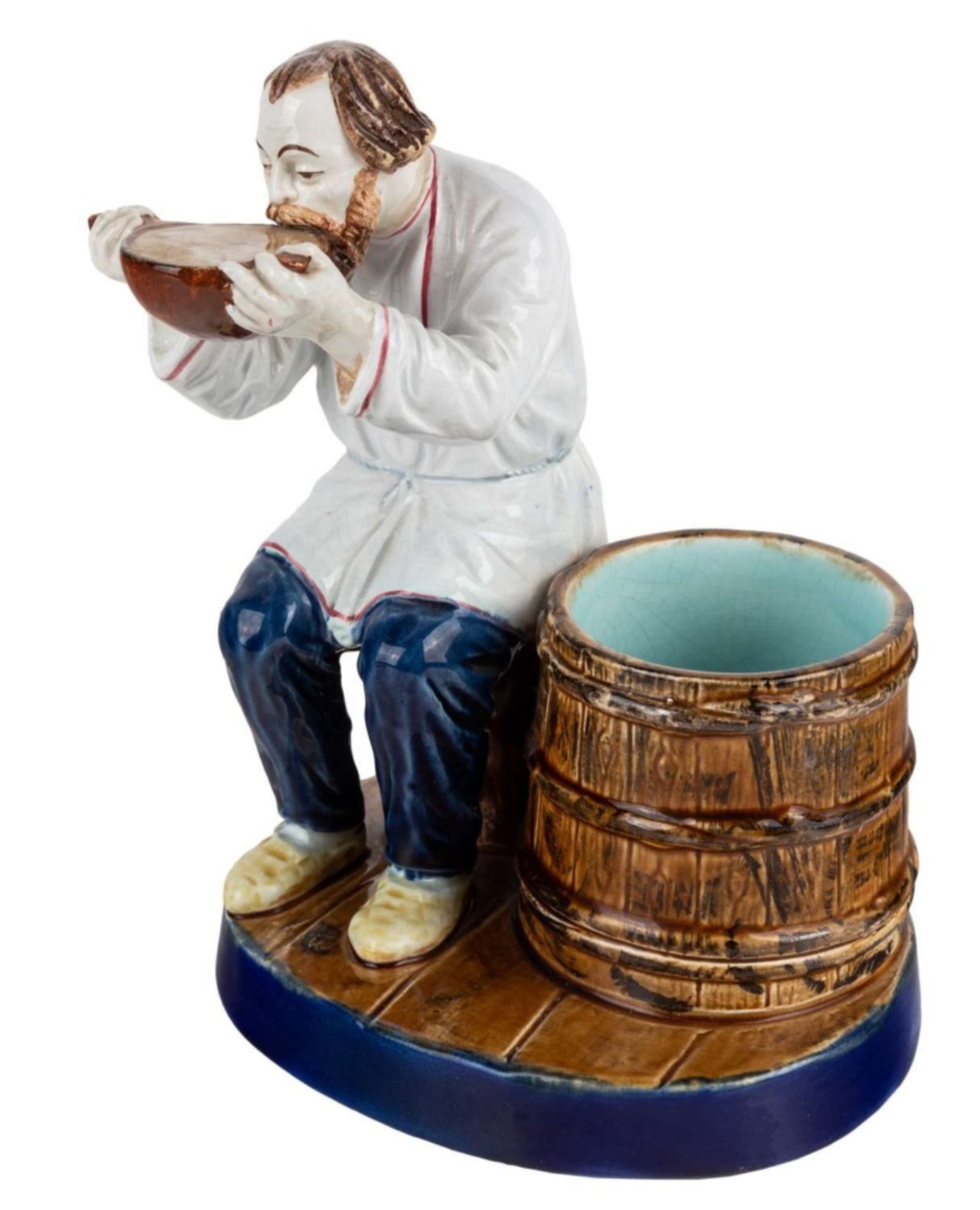 A RUSSIAN PORCELAIN FIGURE OF A PEASANT DRINKING FROM A KOVSH, KUZNETSOV PORCELAIN FACTORY, TVER