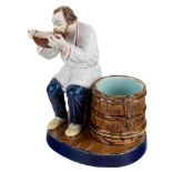 A RUSSIAN PORCELAIN FIGURE OF A PEASANT DRINKING FROM A KOVSH, KUZNETSOV PORCELAIN FACTORY, TVER