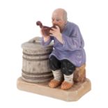 A RUSSIAN PORCELAIN FIGURE OF A PEASANT DRINKING FROM A KOVSH, GARDNER PORCELAIN FACTORY, VERBILKI