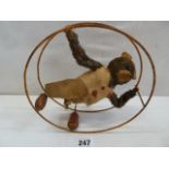 Early 20thC tinplate clockwork plush Teddy Bear in rolling wheel (clothing in poor condition)
