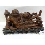 Oriental hardwood carving of Li Diehguei reclining drinking from tea pot with child on stand.