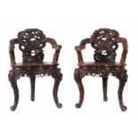 Paar ArmlehnstühleChina, 20. Jh., Holz, zwei dreibeinige Stühle, die Sitzflächen beschnitzt mit