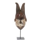 Maske mit hörnerartiger FrisurNigeria, Stamm der Ogoni, Holz mit teils krustiger Oberfläche und