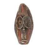 Schwarz gefärbte MaskeAfrika, Holz, mit sternförmig geschnitzten Augenkonturen und rot angemalten