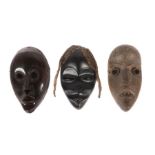 Drei Masken der DanElfenbeinküste, Holz geschnitzt mit Augen- und Mundöffnungen und Randbohrungen, 2