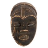 MaskeNigeria (?), Holz geschwärzt, mit eingeschnittenen Stirnlinien und Zähnen, H: 40 cm.- - -25.