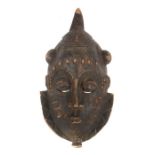 MaskeElfenbeinküste, Holz mit krustiger Patina, mit Schmucknarben und Kinnbart, H: 44 cm.- - -25.