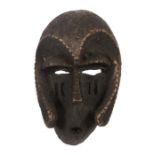 Maskeafrikanisch, Holz geschwärzt, mit gekerbten Gesichtskonturen und Narbenschmuck, H: 31 cm.- - -