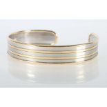 Armreifmodern, Weiß-/Gelbgold 750, gebogenes Weißgold-Band (B: ca. 1 cm) mit Gelbgold-