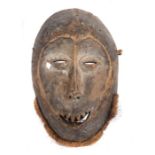 Maske der LegaDR Kongo, Holz geschwärzt und mit Kalkresten, mit Faserbart und geschnitzten Zähnen,