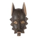 Maske der BauleElfenbeinküste, Holz geschwärzt, mit gezackter Kontur und abstehenden
