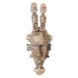 Figurenbekrönte Kpelie Maske der SenufoElfenbeinküste, Holz mit gekalkten Details, H: 60 cm.- - -