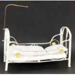 PUPPENBETTWeiß lackiertes Metall, mit Bettwäsche. 21x34x16cmA DOLL'S BED White lacquered metal, with