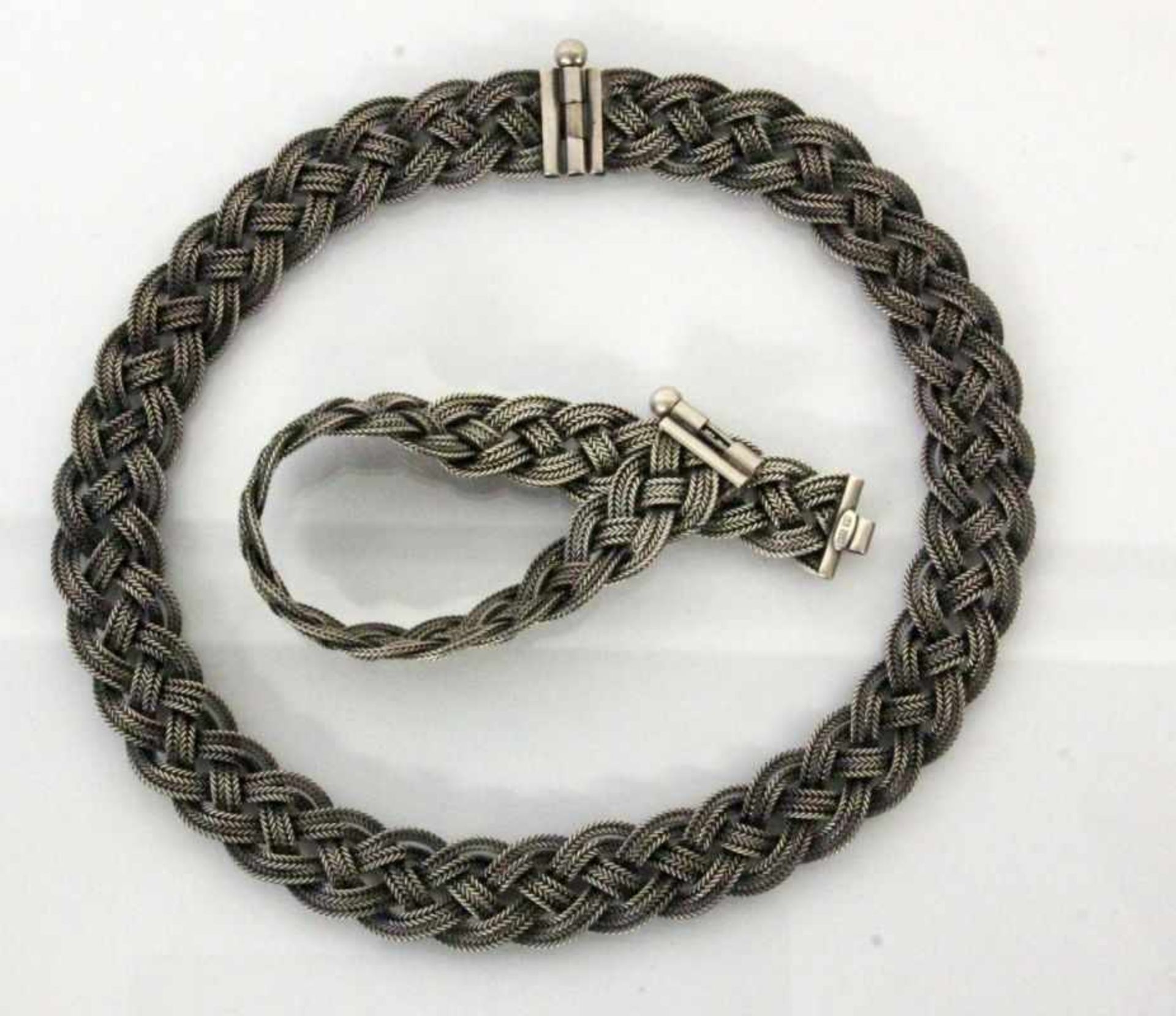 TRACHTENHALSKETTE UND -ARMBANDSilber. Geflochtener Dekor. L.40/19cm. Brutto ca.77gA COSTUME NECKLACE