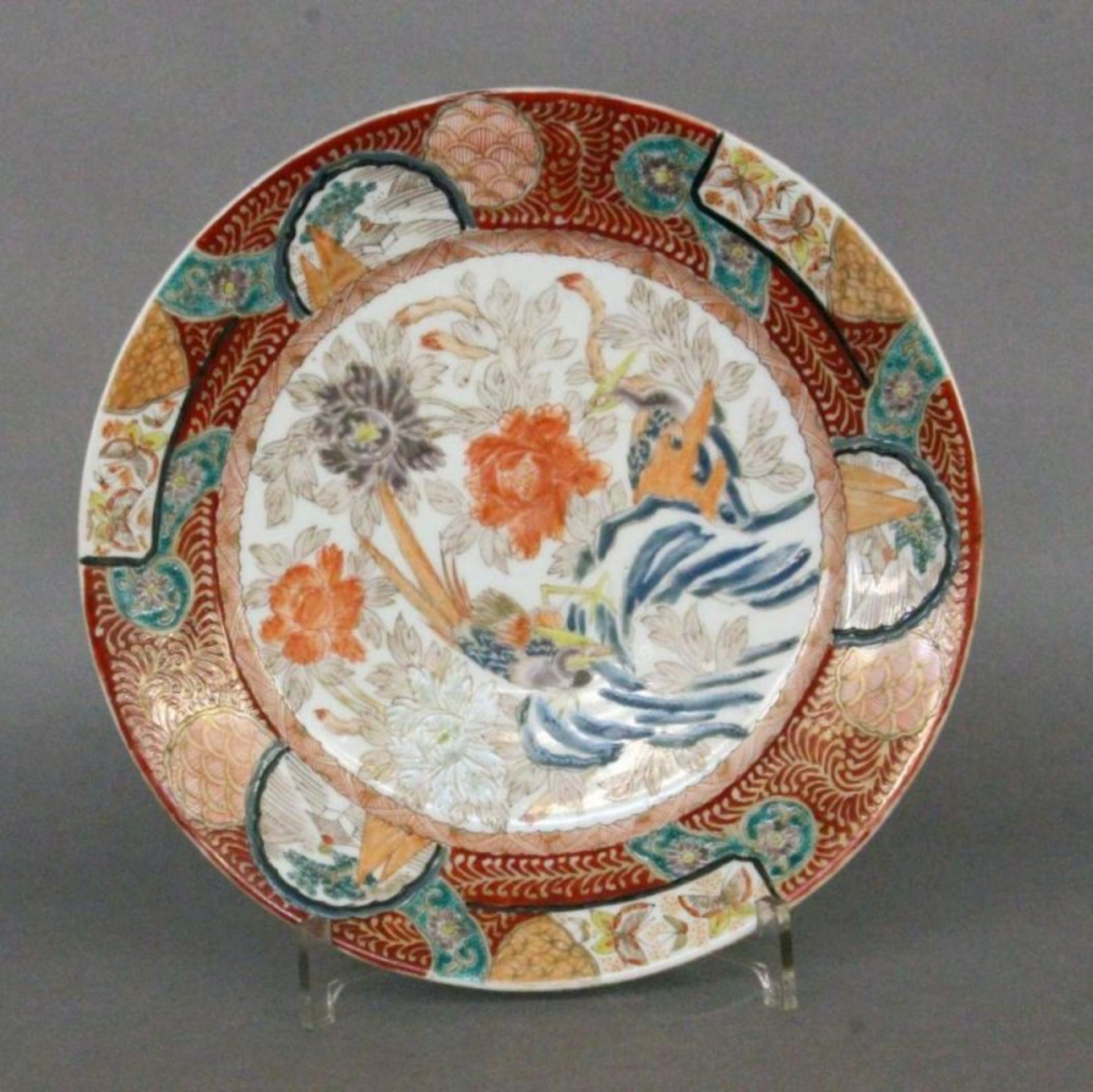 TELLER IM IMARI STILJapan Polychrome Bemalung mit Blumen und exotischen Vögeln. Bodenmarke. D.26,5cm